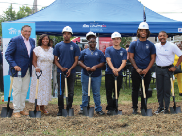  group of people standing with hard hats and shovels